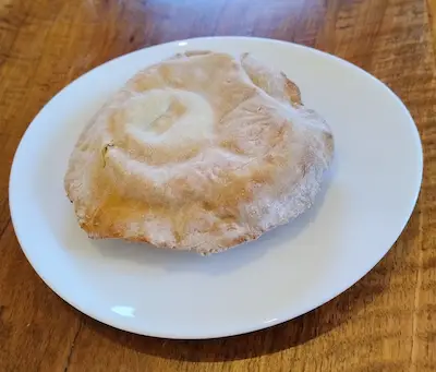 Immagine di un panino allo yogurt su un piatto. Il panino è gonfio, per questo il nome palla